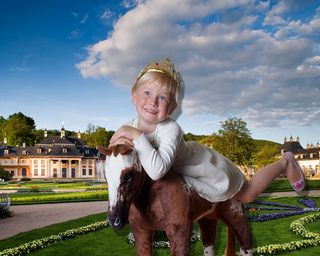 Mädchen auf Plüsch-Pferd im Park Pillnitz Mädchen sitzt auf einem Plüsch-Pferd im Park Pillnitz