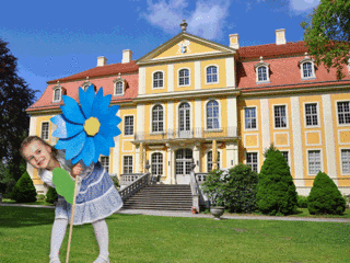 Mädchen mit Blume steht vor dem Barockschloss Rammenau Mädchen mit Blume steht vor dem Barockschloss Rammenau