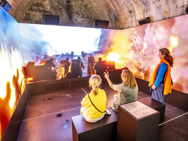 Besucher schauen sich den Film mit dem Angriffsszenario auf die Festung Königstein an