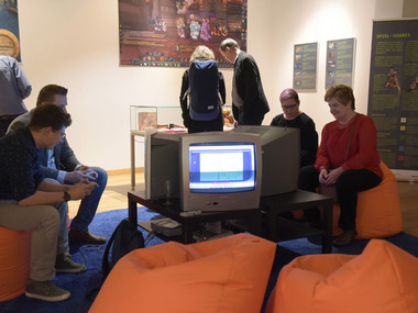 Besucher sitzen vor alten Monitoren und spielen Computerspiele