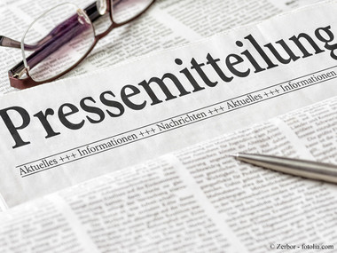 Eine Brille liegt über einer Zeitung auf der das Wort Pressemeldungen groß zu lesen ist