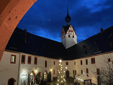 Blick in den Burghof am Abend, dunkelblauer Himmel, Weihnachtsbaum in der Hofmitte umgeben von Ständen