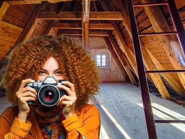 Ein Frau mit großer Foto-Kamera auf dem Dachoden der Georgenburg