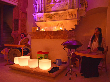 Künstlerin Manuela Ina Kirchberger spielt auf ihren Kristallklangschalen in der romantisch beleuchteten Schlosskapelle St. Anna von Schloss Rochsburg