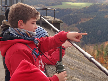 Ein Junge deutet mit dem Finger auf einen Punkt in der Umgebung der Festung