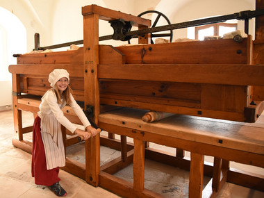 Mädchen an der historischen Wäschemangel